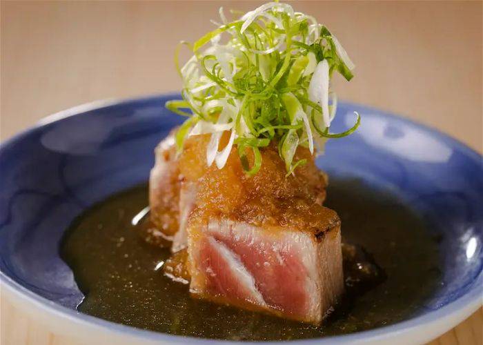 A serving at flame-grilled tuna at Sushi Tenkawa, garnished with thinly sliced spring onion.